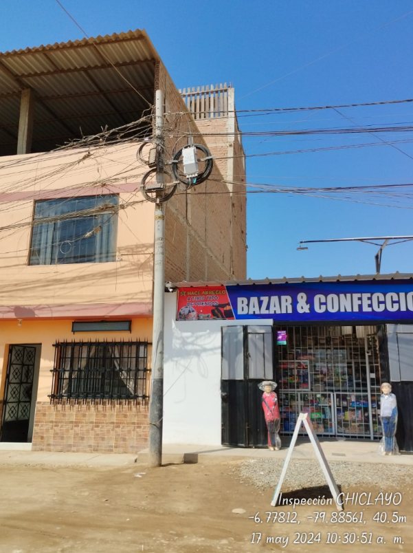 Poste compartido en Chiclayo con caja de empalme y rollos de cable de reserva acumulados, registrado en una inspección de planta externa